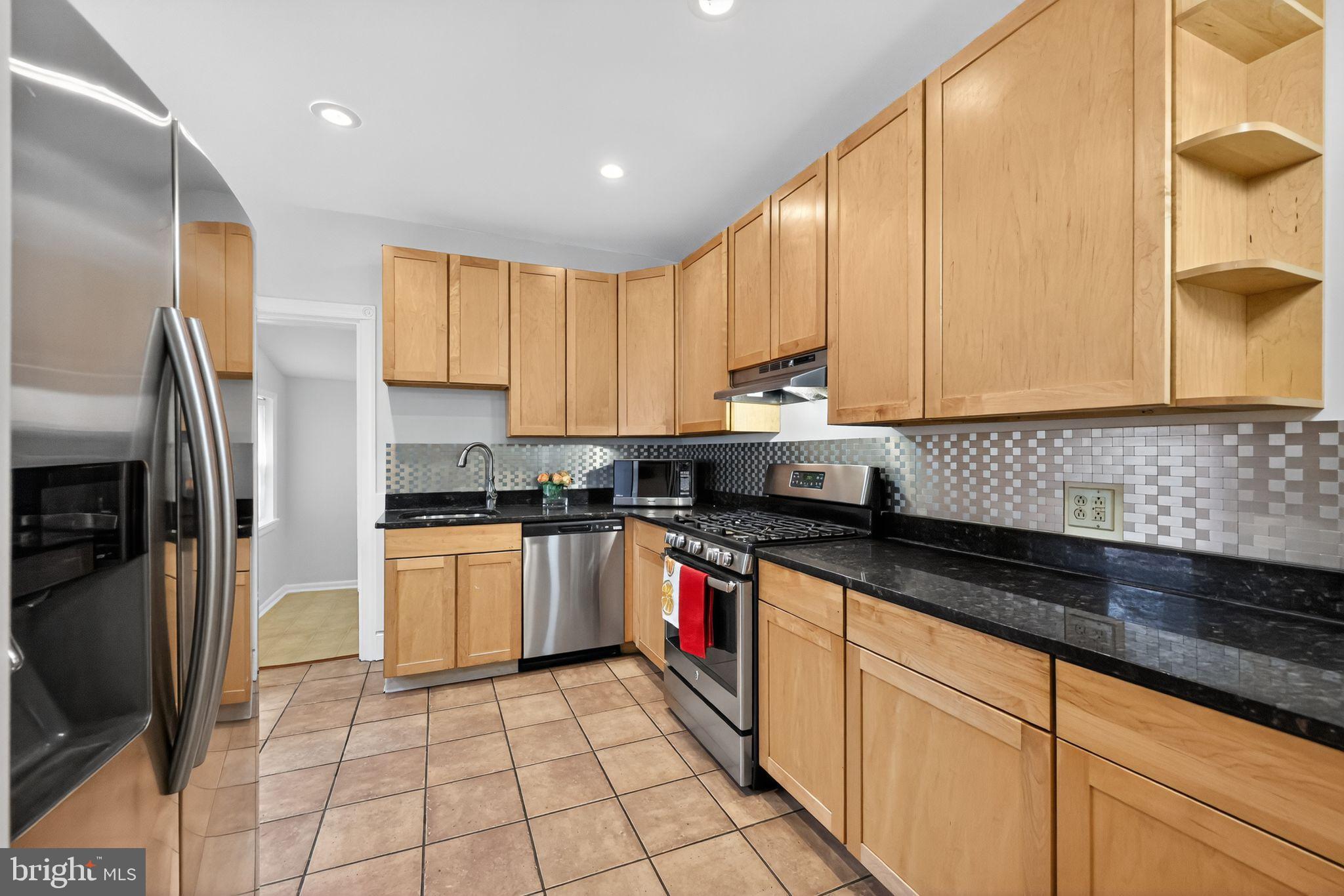 5443 Morris Street Philadelphia, PA 19144 - Photo 13 of 37 a kitchen with stainless steel appliances granite countertop a stove a sink and a refrigerator
