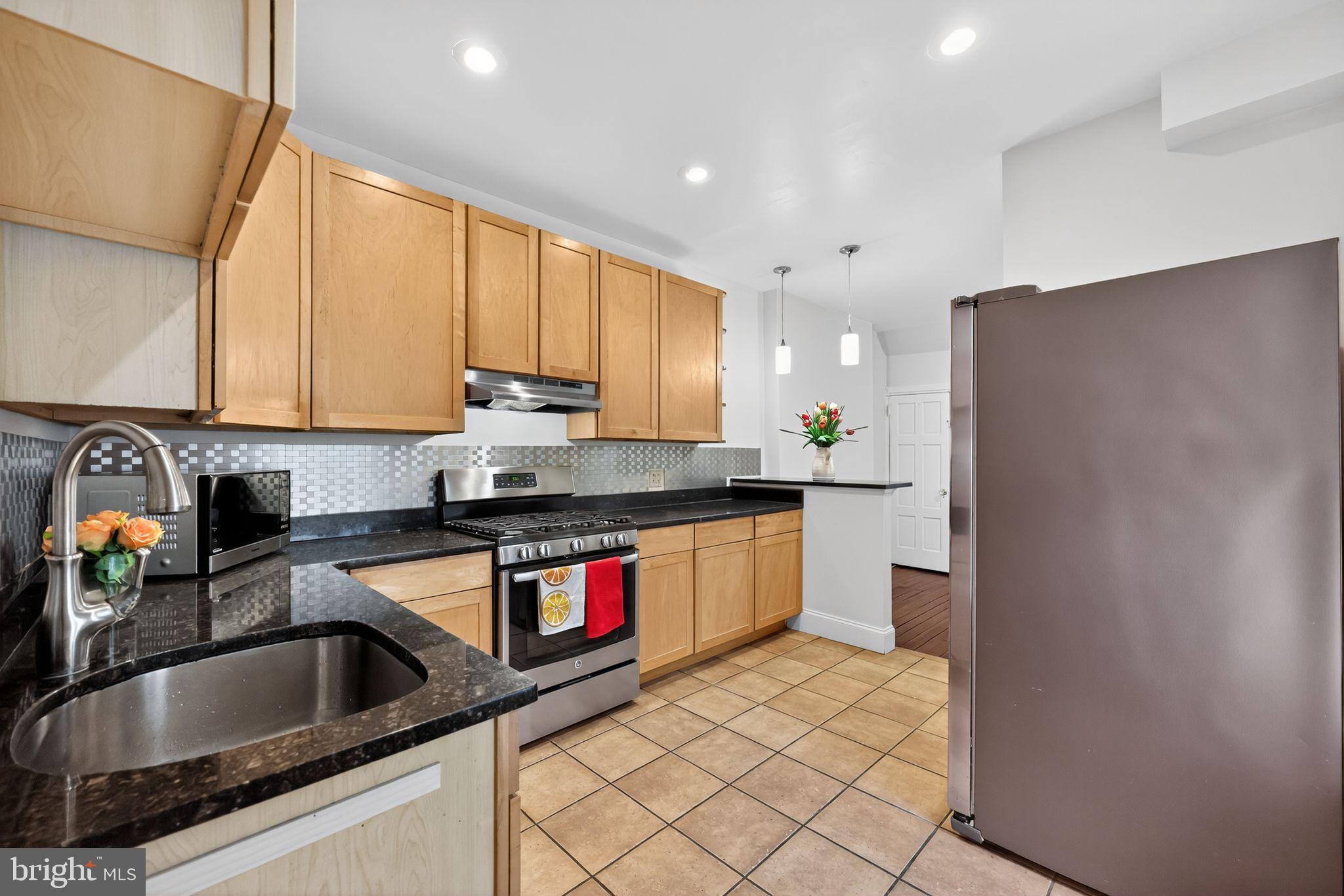 5443 Morris Street Philadelphia, PA 19144 - Photo 16 of 37 a kitchen with stainless steel appliances granite countertop a sink refrigerator and cabinets