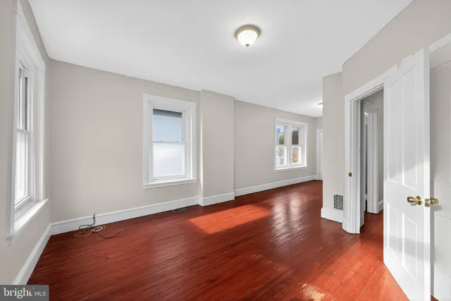 an empty room with wooden floor and a window