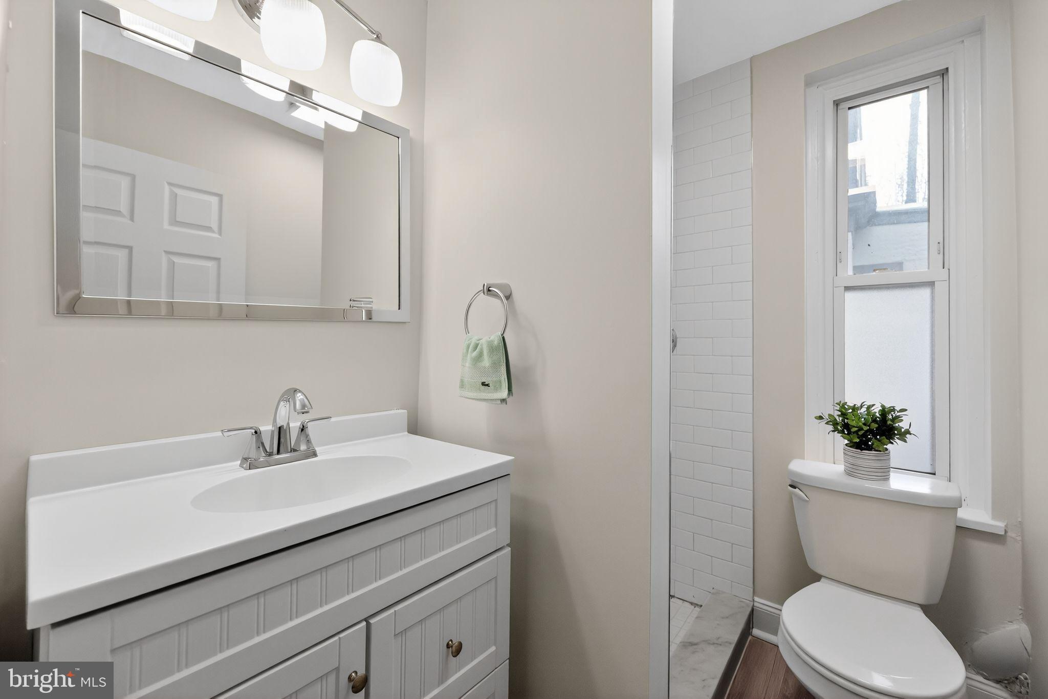 5443 Morris Street Philadelphia, PA 19144 - Photo 24 of 37 a bathroom with a sink a mirror a toilet and a window