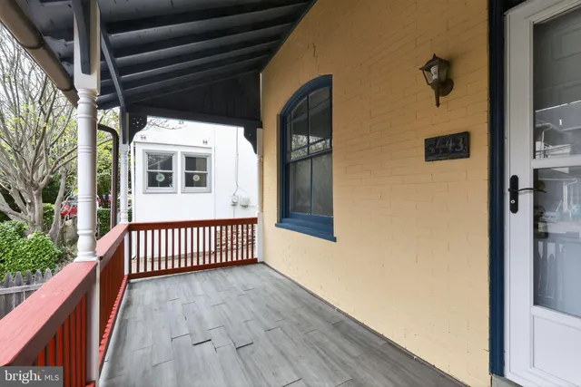 a view of a porch with wooden floor and floor to ceiling window