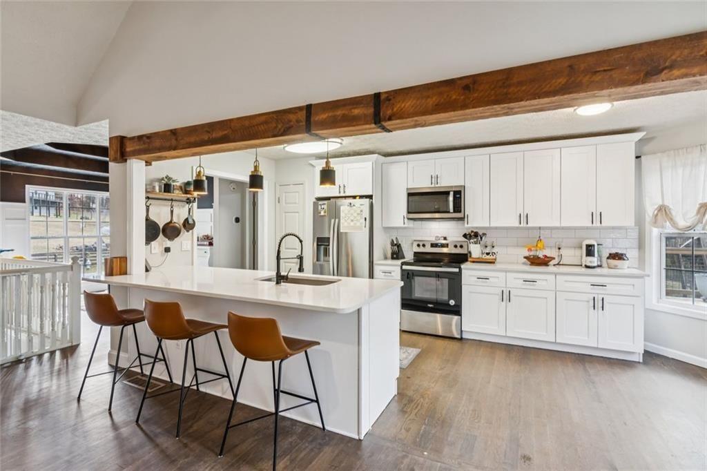 5595 Vaughn Road Woodstock, GA 30188 - Photo 11 of 42 a kitchen with granite countertop white cabinets and stainless steel appliances