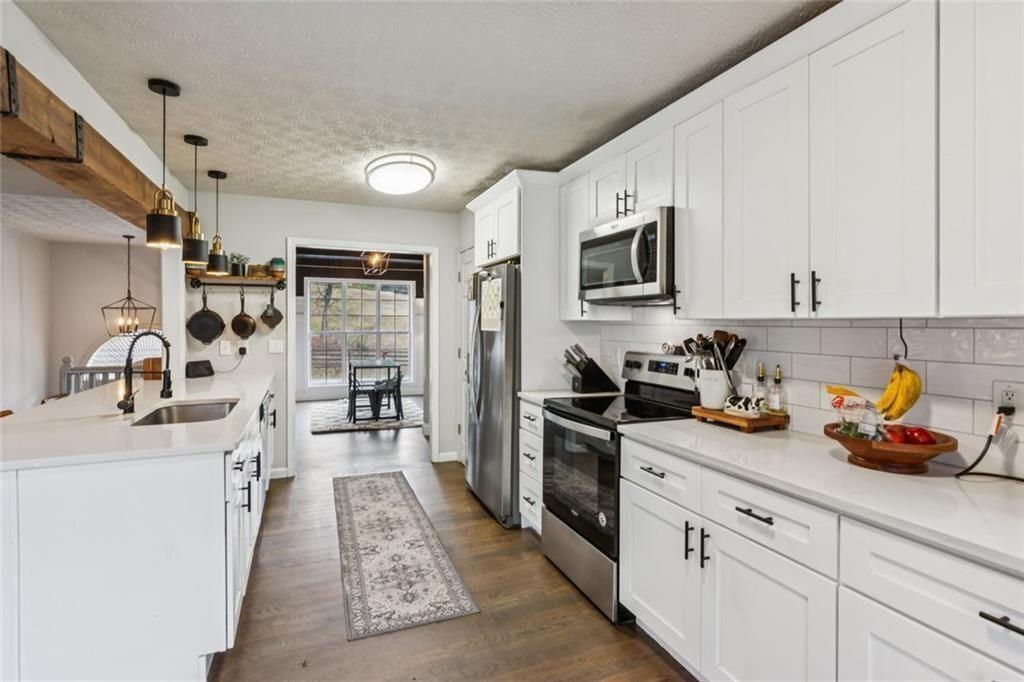 5595 Vaughn Road Woodstock, GA 30188 - Photo 12 of 42 a kitchen with stainless steel appliances granite countertop a sink stove refrigerator and cabinets