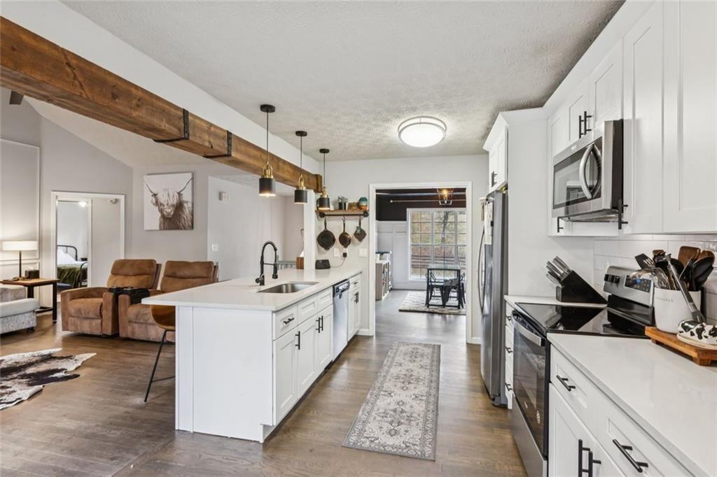 5595 Vaughn Road Woodstock, GA 30188 - Photo 13 of 42 a kitchen with stainless steel appliances kitchen island granite countertop a sink stove and refrigerator