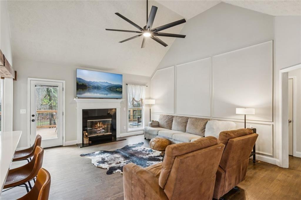 5595 Vaughn Road Woodstock, GA 30188 - Photo 8 of 42 a living room with furniture a fireplace and a ceiling fan