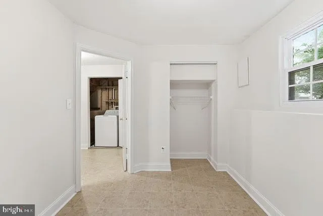 an empty room with windows and closet