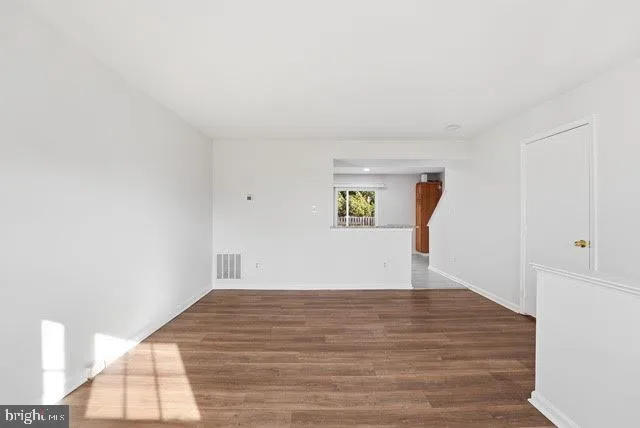 a view of empty room with wooden floor