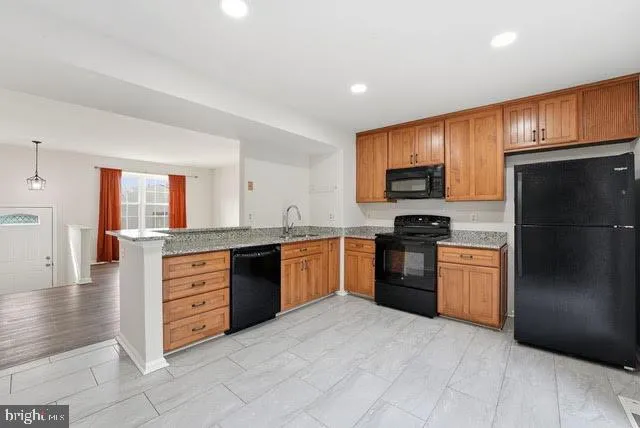 a kitchen with granite countertop stainless steel appliances and refrigerator