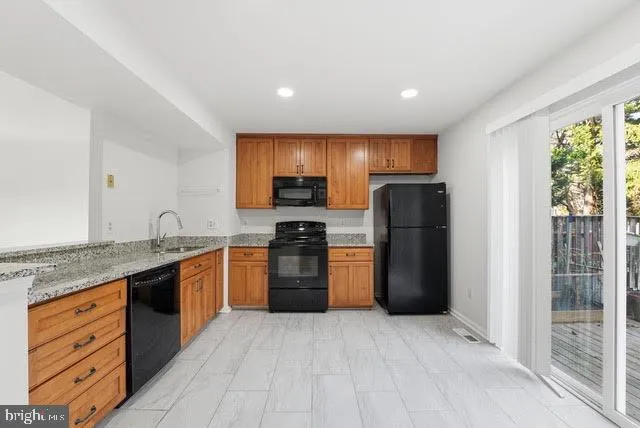 a kitchen with stainless steel appliances granite countertop a refrigerator stove and sink
