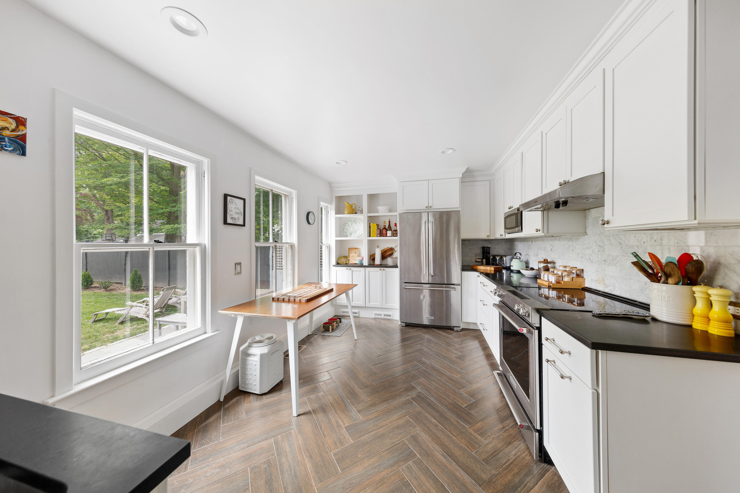25 Raymond Street Darien, CT 06820 - Photo 10 of 28 a kitchen with stainless steel appliances a stove a sink dishwasher a refrigerator a dining table and chairs with wooden floor