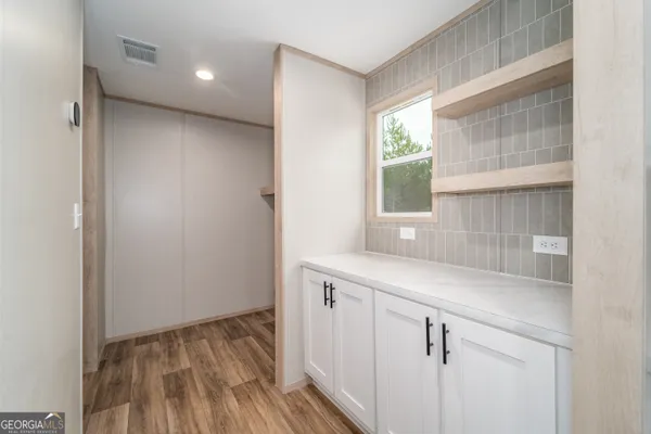 a kitchen with a sink and wooden floor