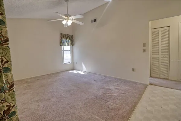 en empty room with windows and ceiling fan