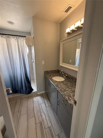 a bathroom with a granite countertop sink and a mirror