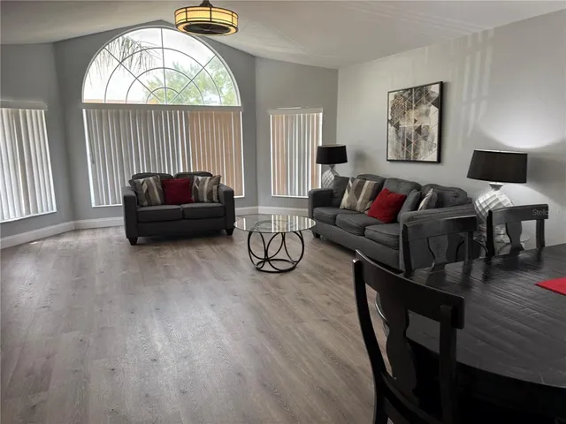 a living room with furniture a fireplace and a large window