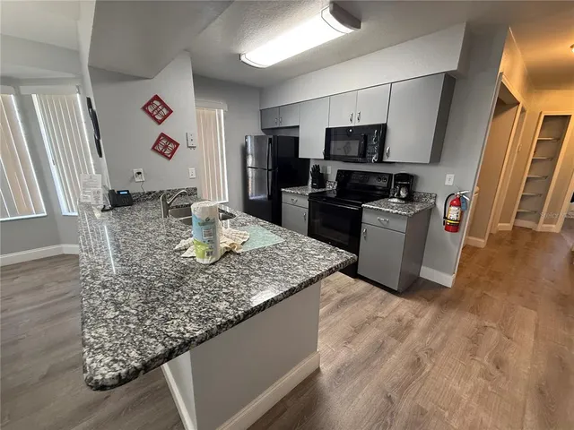 a kitchen with stainless steel appliances granite countertop a sink dishwasher microwave stove and refrigerator