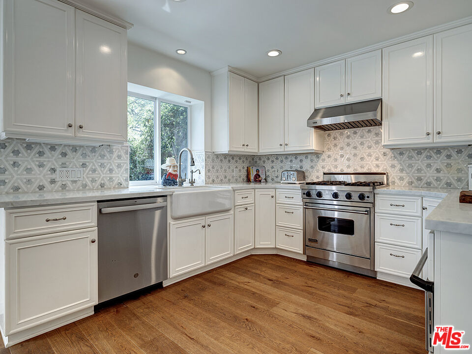 1314 Preston Way Venice, CA 90291 - Photo 13 of 30 a kitchen with granite countertop white cabinets and white appliances with wooden floor