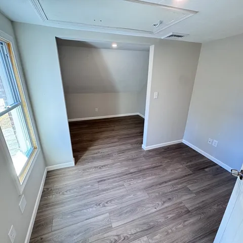 a view of empty room with wooden floor