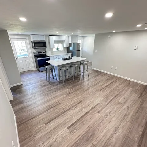 a kitchen with a wooden floor and chairs