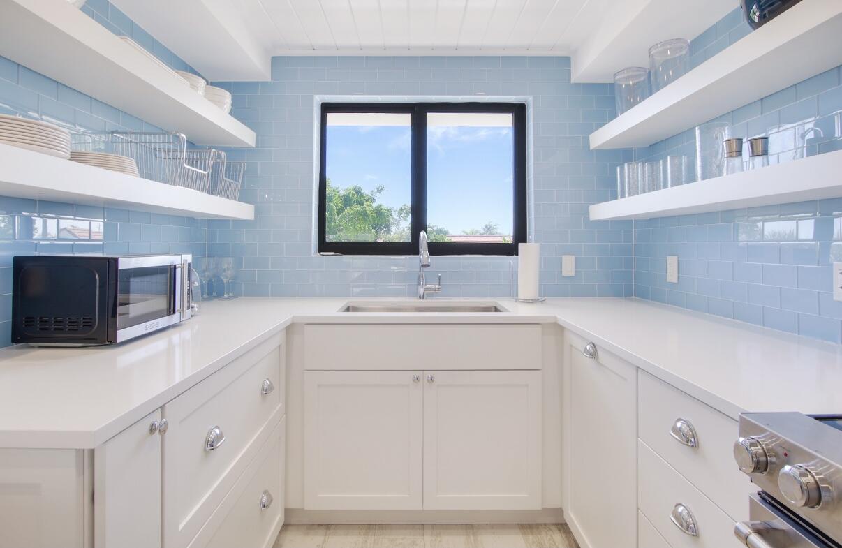420 Celestial Way, Unit 303 Juno Beach, FL 33408 - Photo 20 of 39 a kitchen with white cabinets and a sink