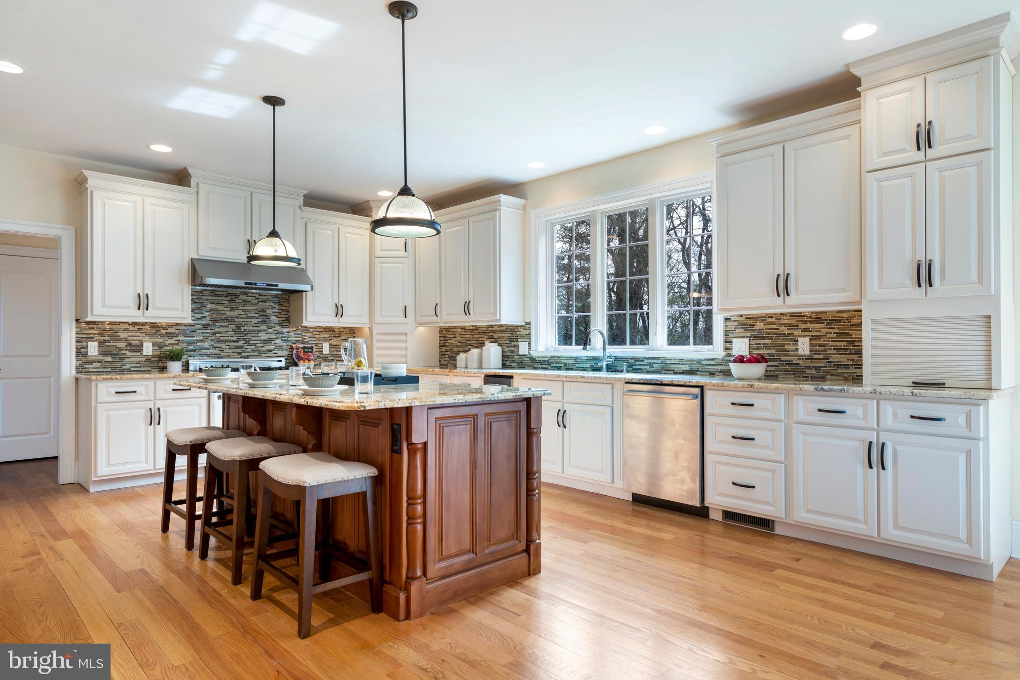 1315 Prospect Hill Road Villanova, PA 19085 - Photo 7 of 24 a kitchen with kitchen island granite countertop a sink cabinets and wooden floor