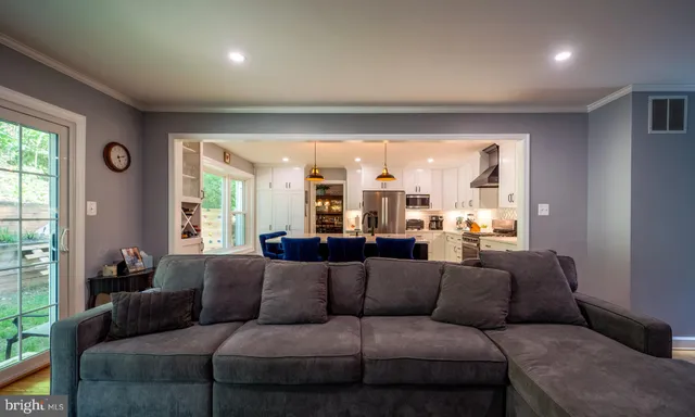 a kitchen with stainless steel appliances granite countertop a stove top oven a sink dishwasher a dining table and chairs with wooden floor