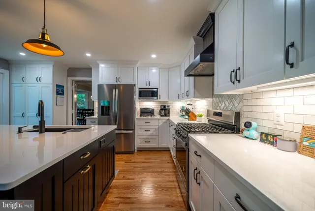 a bathroom with a toilet a sink a mirror and a window