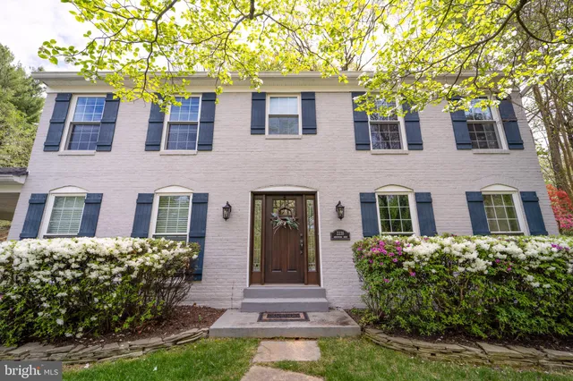 a front view of house and yard with beautiful flowers and green space