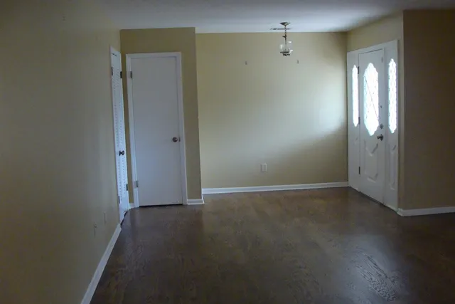an empty room with wooden floor and a window