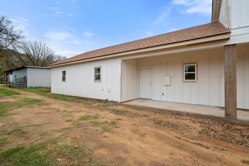 2877 Conveyor Drive, Unit B Burleson, TX 76028 - Photo 20 of 22 Back of house with a shingled roof and board and batten siding