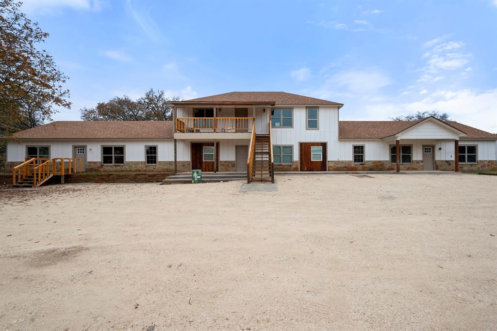 2877 Conveyor Drive, Unit B Burleson, TX 76028 - Photo 21 of 22 View of front of house with stairway, stone siding, board and batten siding, and roof with shingles