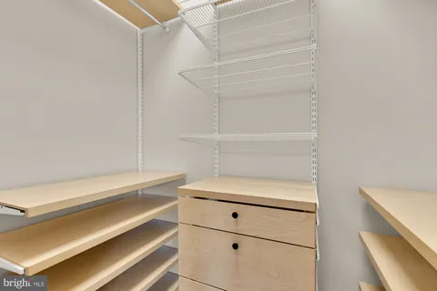 a view of walk in closet with empty racks