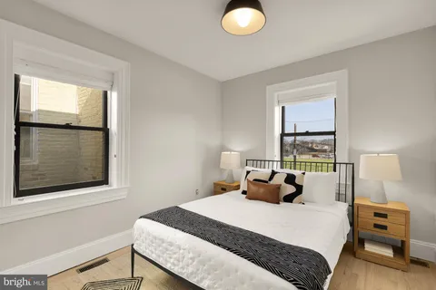 a bedroom with a bed and wooden floor