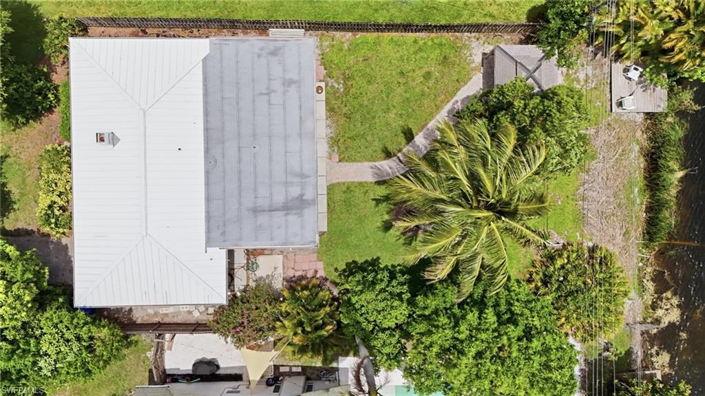 1316 Rordon Avenue Naples, FL 34103 - Photo 34 of 38 Aerial view showcasing a property with a white standing seam metal roof and a flat gray roof section