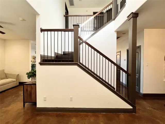 a view of staircase with railing and white walls