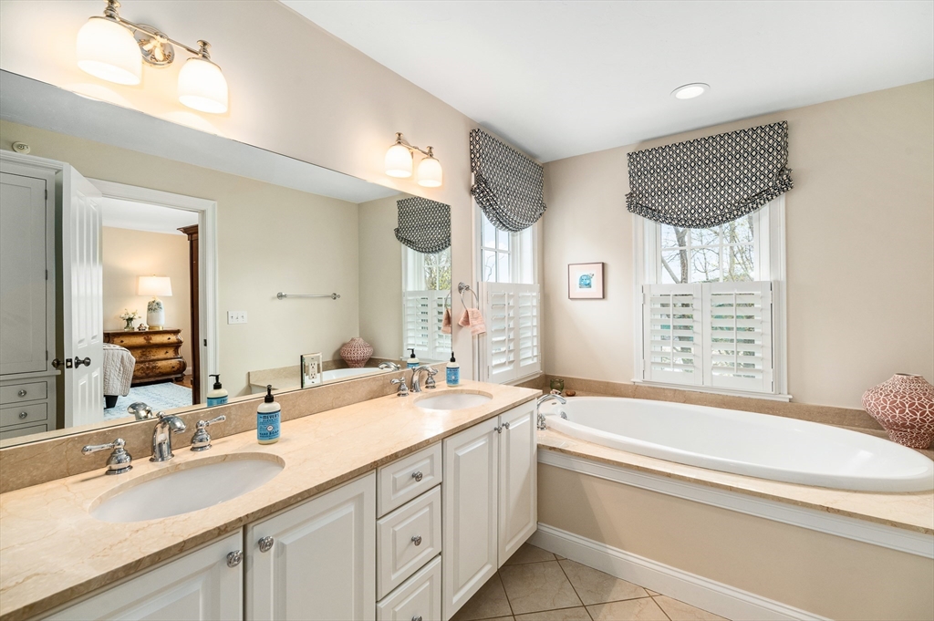 6 Essex Road, Unit 8 Ipswich, MA 01938 - Photo 17 of 35 a bathroom with a double vanity sink large mirror and a bathtub