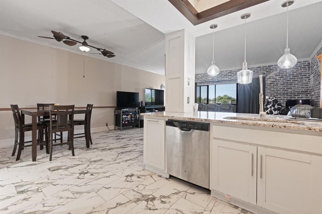 2100 Reflection Bay Drive Arlington, TX 76013 - Photo 2 of 20 a kitchen with stainless steel appliances kitchen island granite countertop a table chairs and a refrigerator