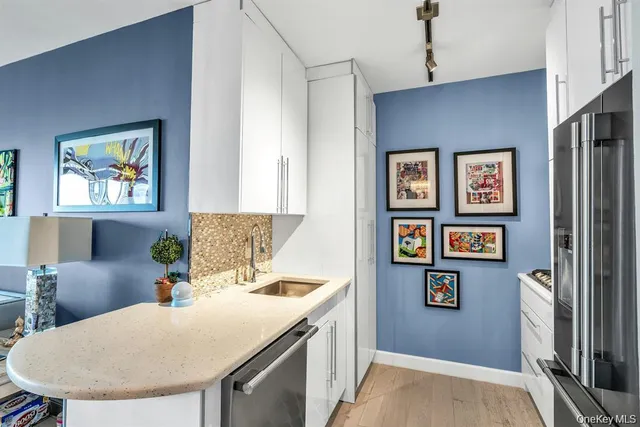 a kitchen with stainless steel appliances granite countertop a sink a stove a refrigerator a dining table and chairs