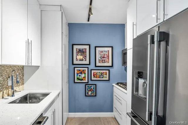 a kitchen with stainless steel appliances granite countertop a refrigerator and a sink