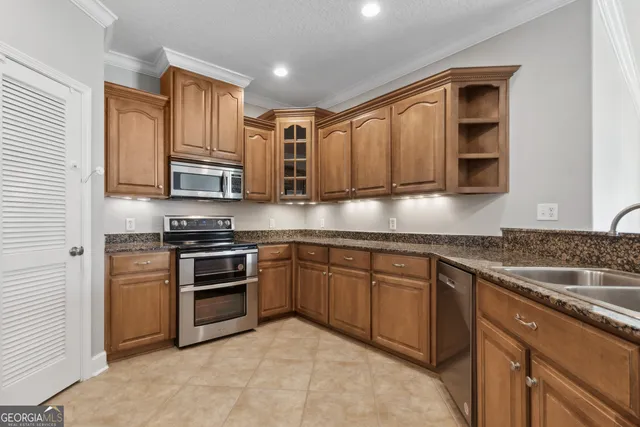 a kitchen with stainless steel appliances granite countertop a stove sink microwave and cabinets