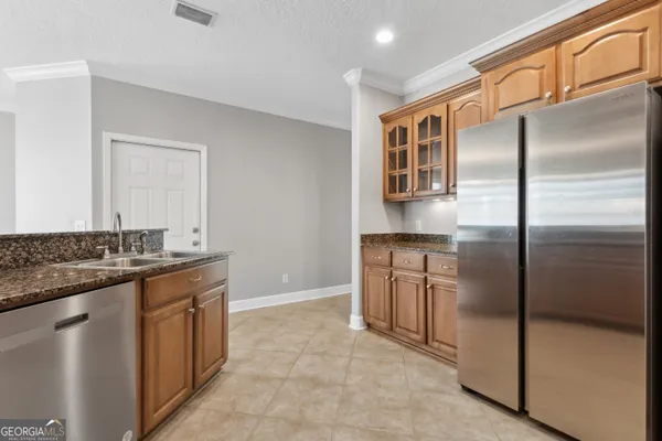 a kitchen with stainless steel appliances granite countertop a refrigerator and a stove