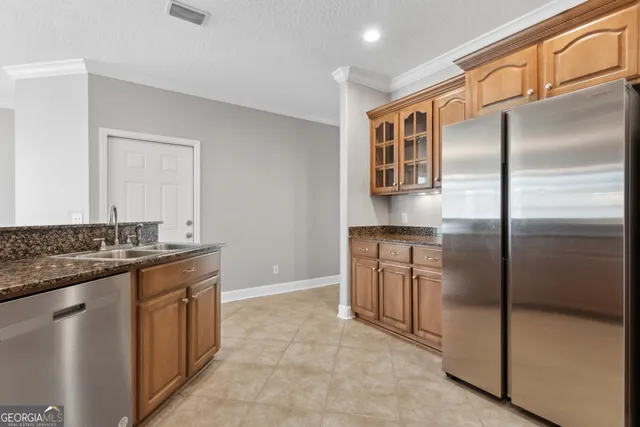 a kitchen with stainless steel appliances granite countertop a refrigerator and a stove