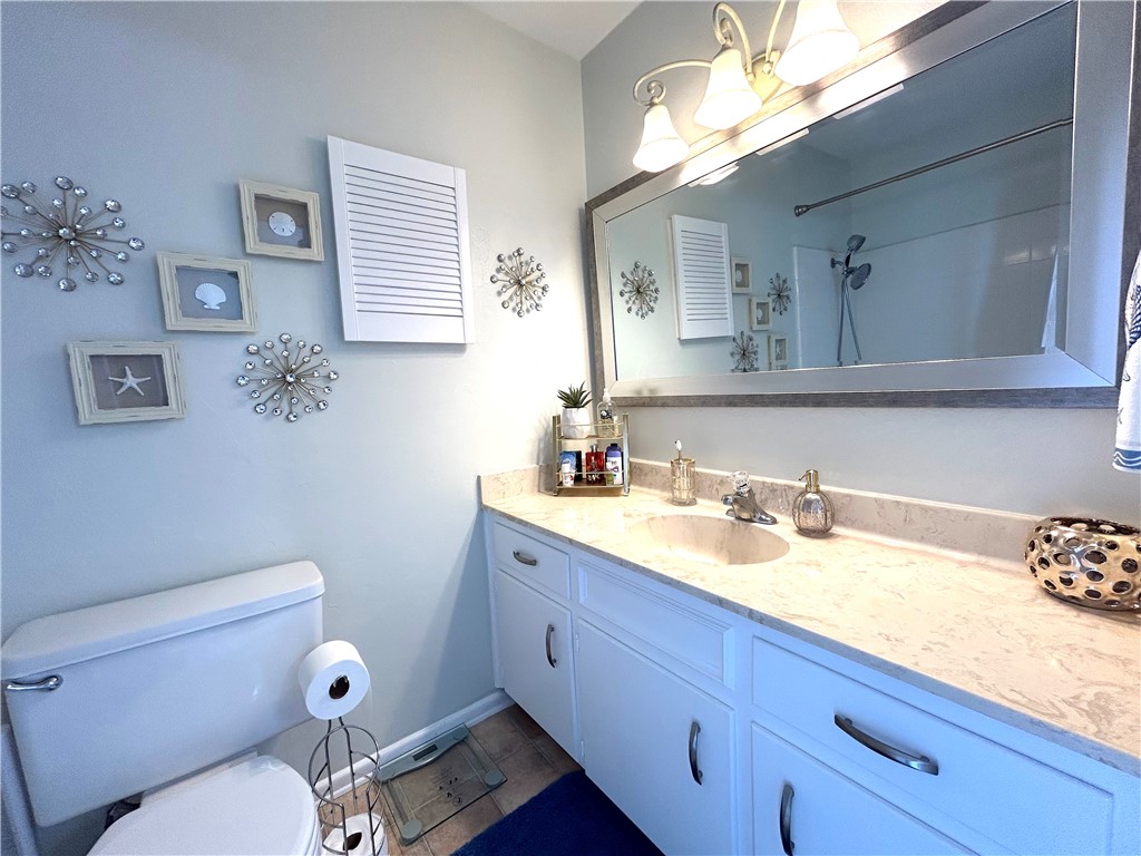 840 Cliff Drive, Unit 4 Portland, TX 78374 - Photo 20 of 32 a bathroom with a granite countertop toilet sink and mirror