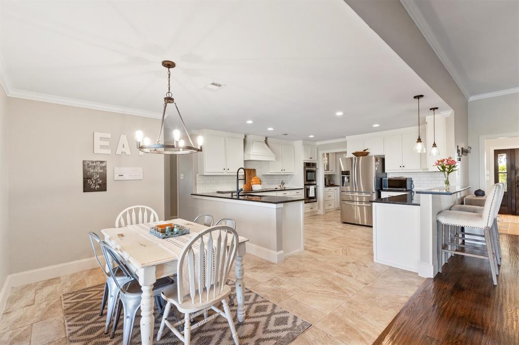 161 Pullen Road McLendon-Chisholm, TX 75032 - Photo 11 of 39 a kitchen with a dining table chairs wooden floor and appliances