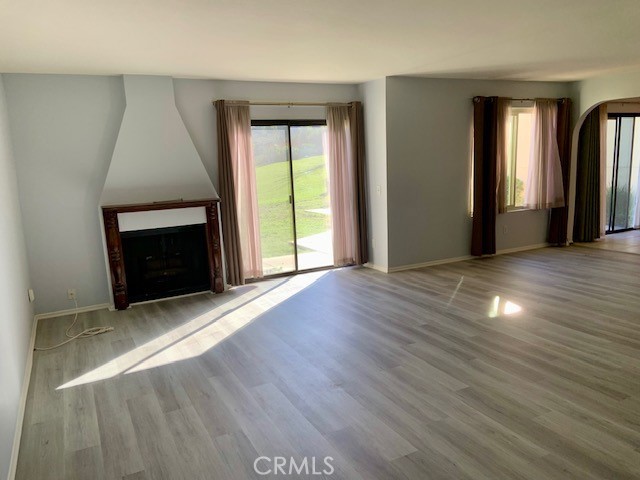 2641 Condor Circle Corona, CA 92882 - Photo 15 of 43 an empty room with wooden floor fireplace and windows
