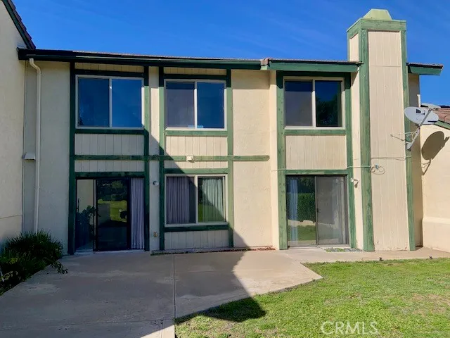 a view of an empty room with wooden floor and a kitchen