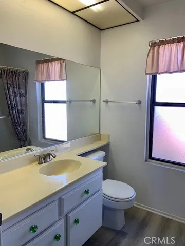 a bathroom with a granite countertop sink toilet and a mirror