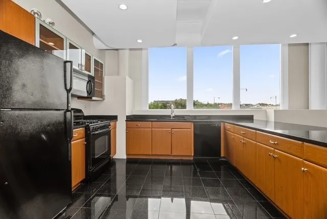 a kitchen with stainless steel appliances a stove a sink and a refrigerator