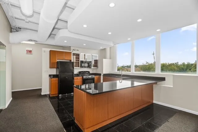 a kitchen with stainless steel appliances granite countertop a sink a stove and a refrigerator