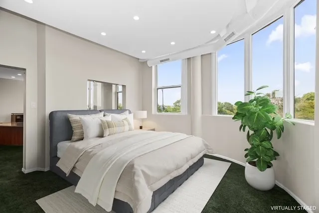 a bedroom with a large bed and a potted plant