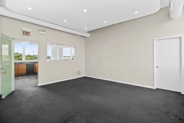 an empty room with a kitchen and windows